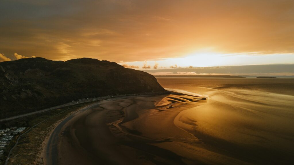 A calm, orange coloured sunset over a beach.